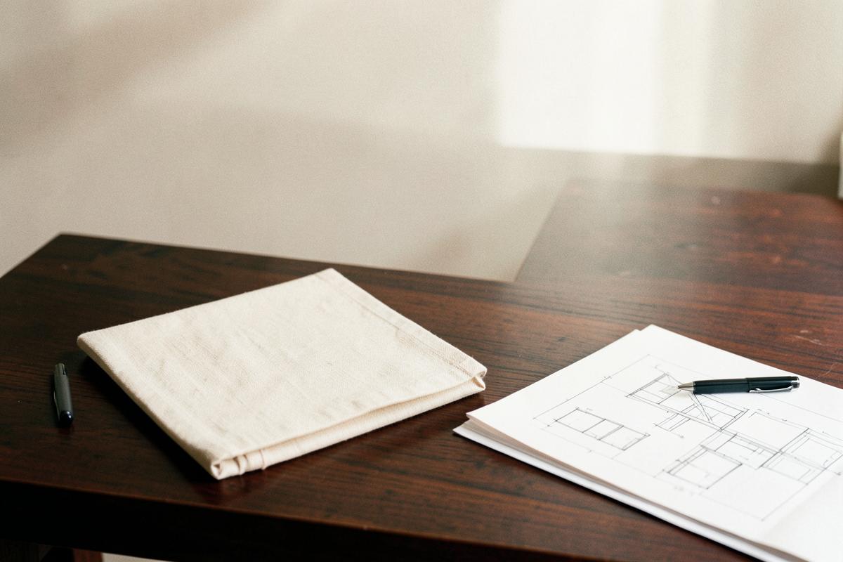 Bureau met notitieboek, pen en bouwtekeningen