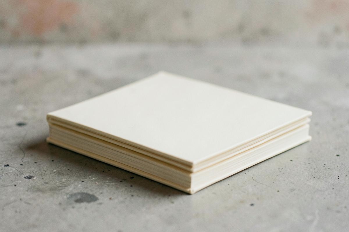 Stapel crèmekleurige portfolioboeken op beton
